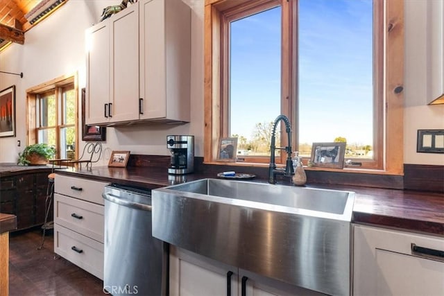 kitchen featuring a sink, butcher block counters, white cabinets, and stainless steel dishwasher