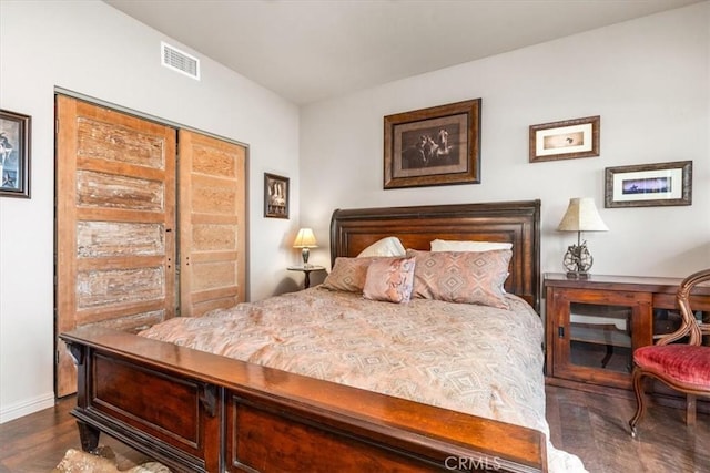 bedroom featuring dark wood-style floors, visible vents, and baseboards