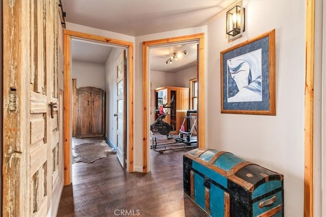 corridor with dark wood-type flooring and baseboards