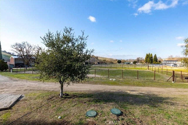 view of yard featuring a rural view and fence