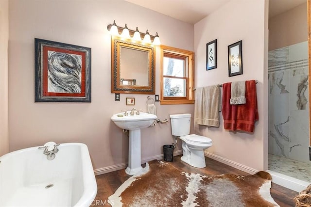 full bathroom featuring a soaking tub, a marble finish shower, toilet, and baseboards