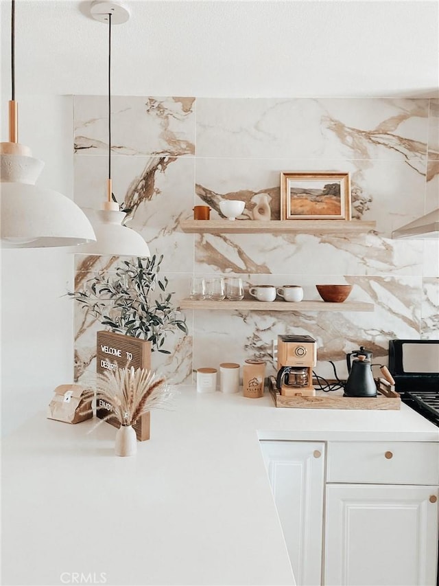 bar with white cabinetry, pendant lighting, stainless steel stove, and decorative backsplash