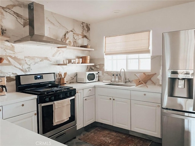 kitchen featuring white cabinetry, sink, exhaust hood, and appliances with stainless steel finishes