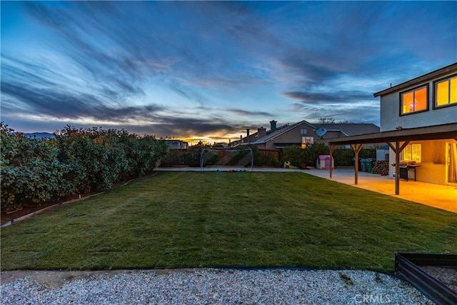 yard at dusk featuring a patio