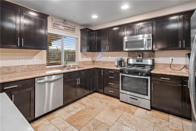 kitchen featuring dark brown cabinetry, sink, and appliances with stainless steel finishes