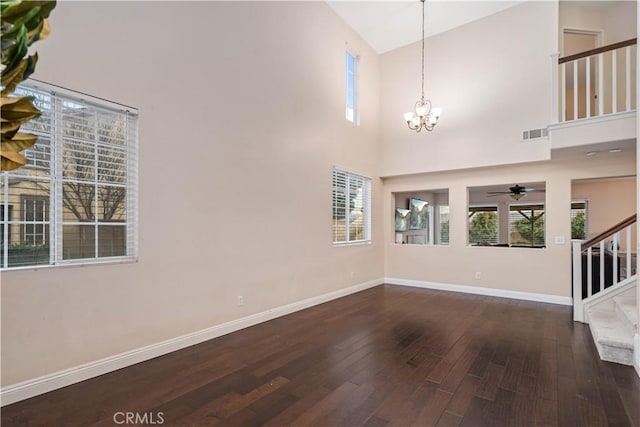 interior space featuring dark hardwood / wood-style flooring, high vaulted ceiling, and an inviting chandelier