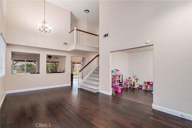 foyer with plenty of natural light, dark hardwood / wood-style floors, a chandelier, and a high ceiling