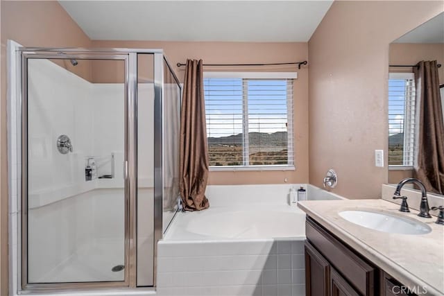 bathroom with independent shower and bath, vanity, and plenty of natural light