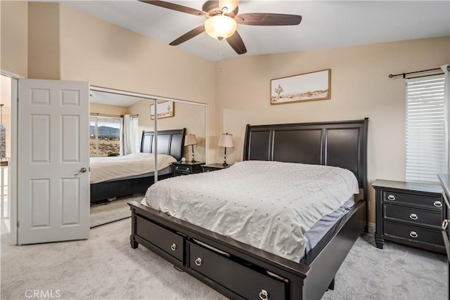 bedroom featuring ceiling fan, light colored carpet, and a closet