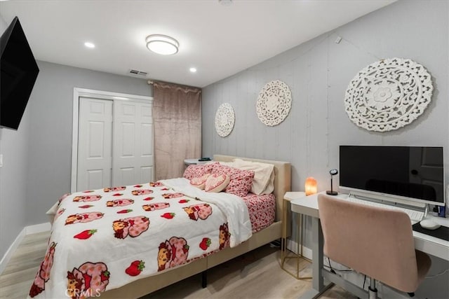 bedroom with light hardwood / wood-style floors and a closet