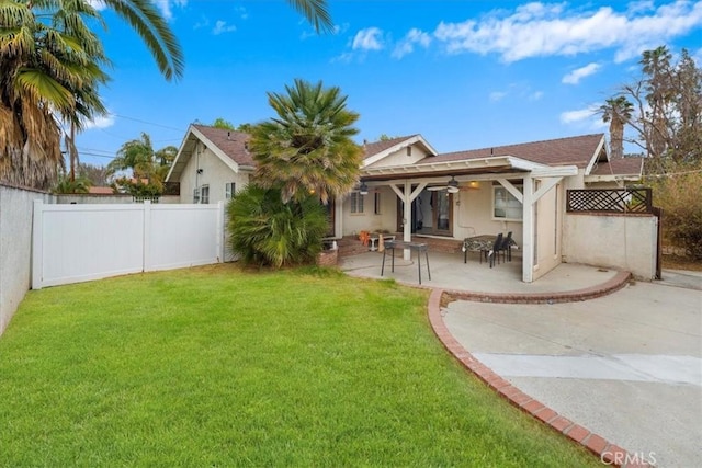 rear view of property featuring a yard and a patio area