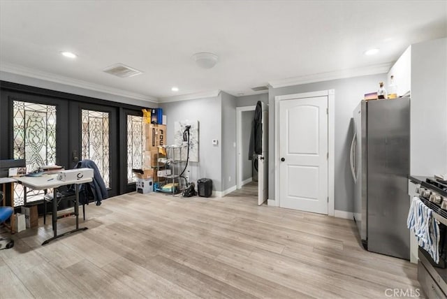 kitchen featuring stainless steel refrigerator, light hardwood / wood-style floors, ornamental molding, gas stove, and white cabinets