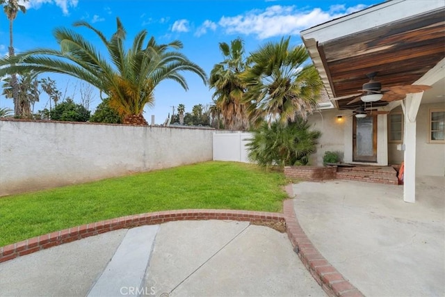 view of yard with ceiling fan and a patio area