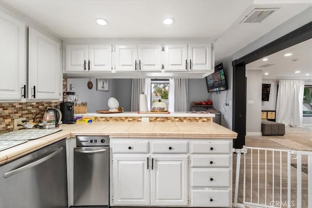 kitchen with white cabinets, decorative backsplash, tile countertops, and dishwasher