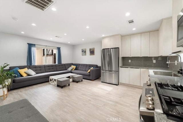 living room featuring sink and light wood-type flooring