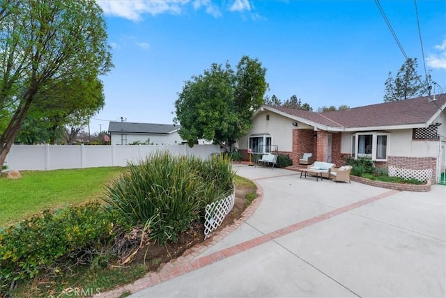 ranch-style house with an outdoor living space, a front lawn, and a patio area