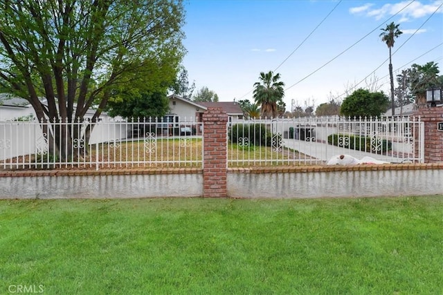 view of gate with a yard