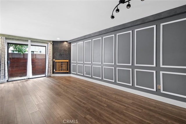 spare room featuring hardwood / wood-style flooring and track lighting