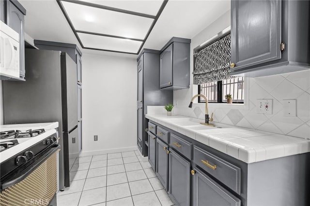 kitchen featuring sink, tile counters, and gray cabinets