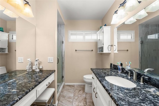 bathroom featuring a shower with door, vanity, and toilet