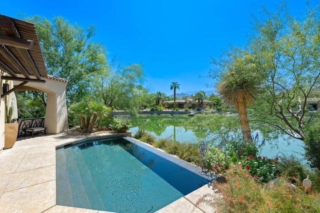 view of pool with a patio and a water view