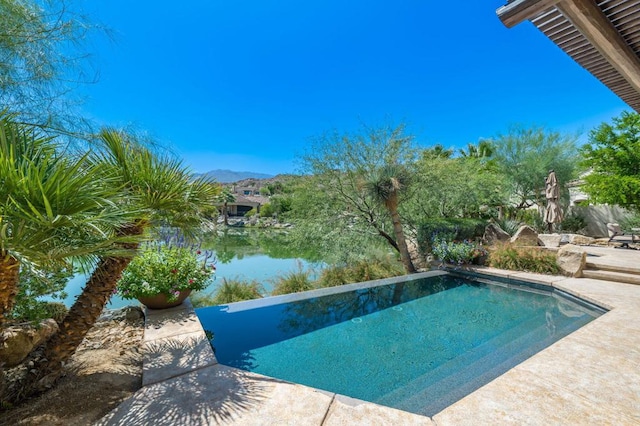 view of swimming pool featuring a water and mountain view and a patio area