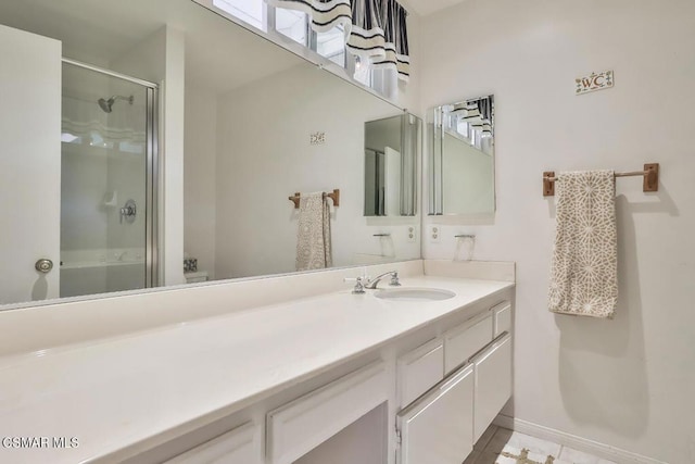 bathroom featuring vanity and a shower with door