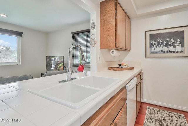 kitchen featuring sink, tile countertops, dishwasher, and plenty of natural light