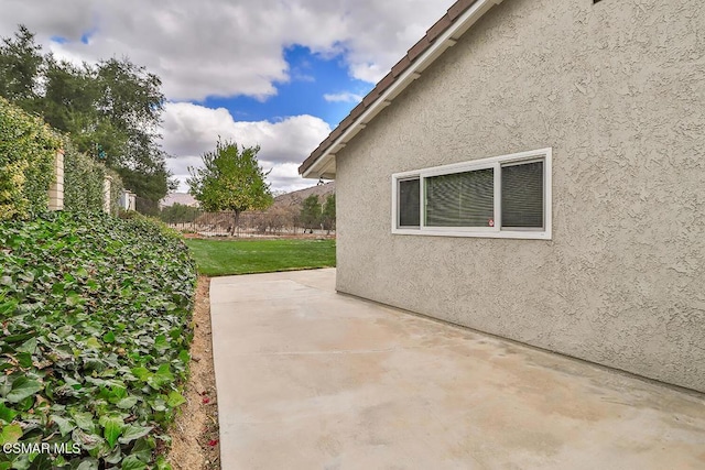 view of side of property featuring a patio and a yard