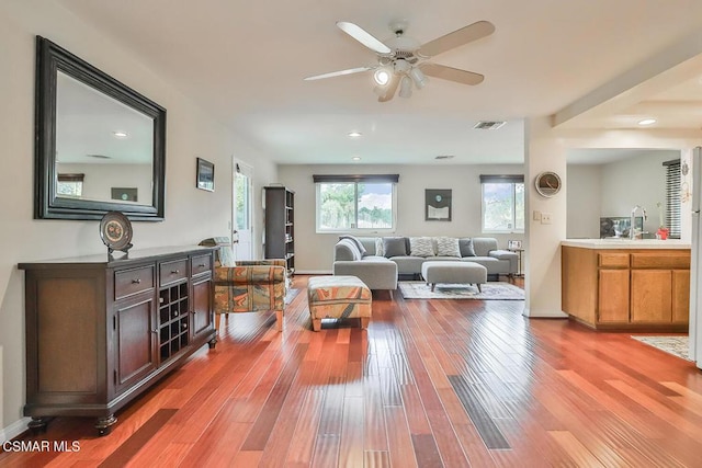 living room featuring sink, hardwood / wood-style floors, and ceiling fan