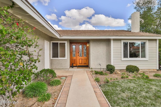 view of exterior entry with a yard