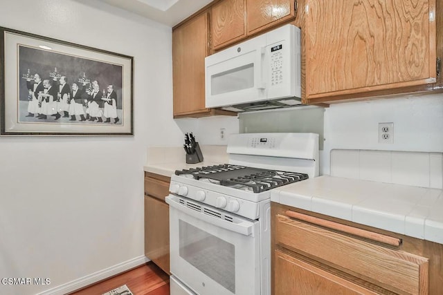 kitchen featuring white appliances, tile countertops, and hardwood / wood-style floors