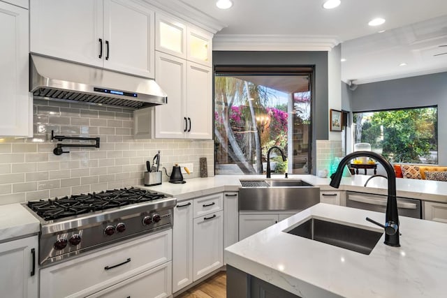 kitchen with sink, white cabinetry, stainless steel gas stovetop, light stone countertops, and exhaust hood