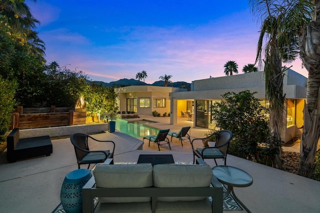 patio terrace at dusk featuring an outdoor living space with a fireplace