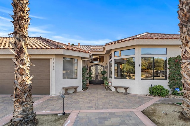 exterior space with a garage and french doors