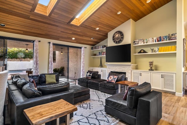 living room with lofted ceiling with skylight, a fireplace, light hardwood / wood-style flooring, and wooden ceiling