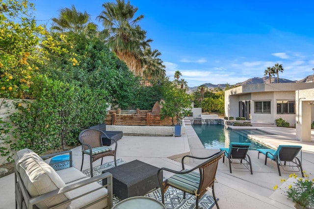 view of swimming pool featuring an outdoor hangout area, a mountain view, and a patio area