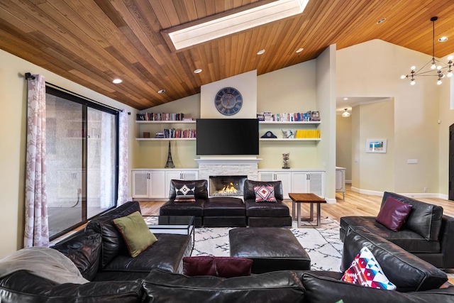 living room featuring wood ceiling, a stone fireplace, vaulted ceiling with skylight, and light hardwood / wood-style flooring