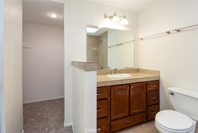 bathroom with vanity, a tile shower, and toilet