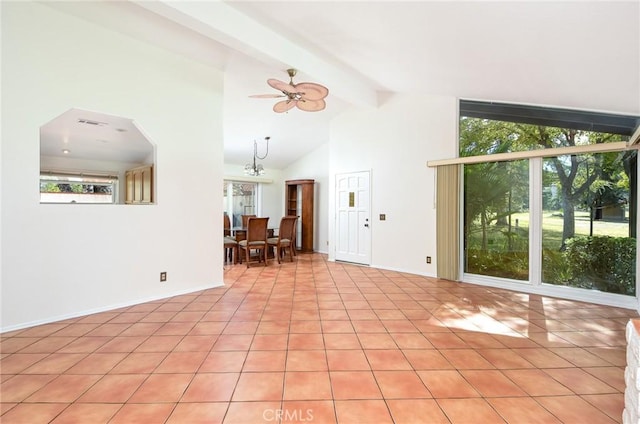 unfurnished living room with high vaulted ceiling, ceiling fan with notable chandelier, beam ceiling, and light tile patterned floors