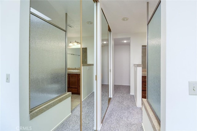 bathroom with walk in shower and vanity