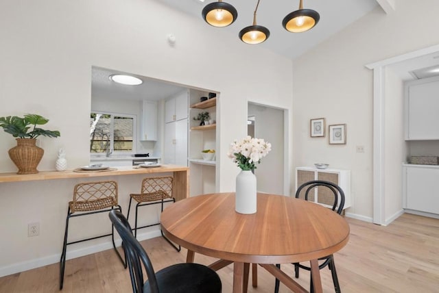 dining space with lofted ceiling and light hardwood / wood-style flooring