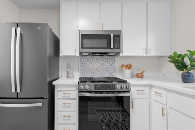 kitchen with backsplash, appliances with stainless steel finishes, and white cabinets