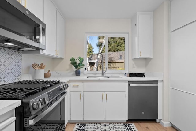 kitchen with white cabinetry, appliances with stainless steel finishes, and sink