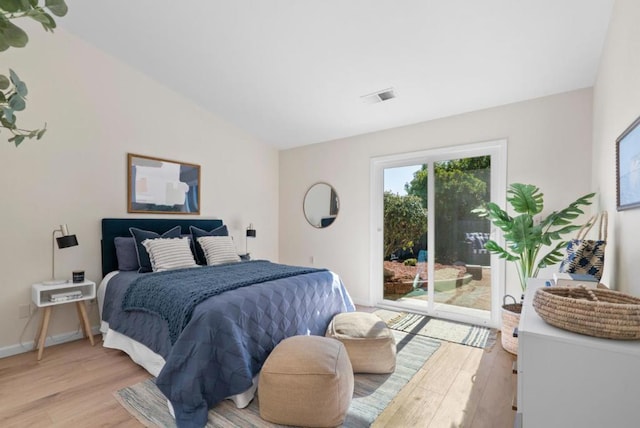 bedroom featuring lofted ceiling, access to outside, and light hardwood / wood-style floors