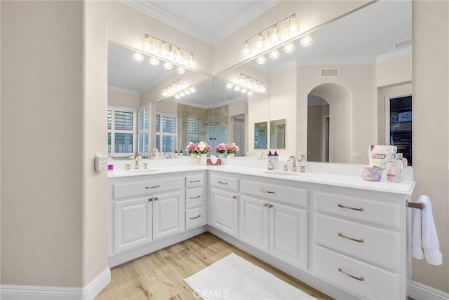 bathroom with crown molding, vanity, and wood-type flooring