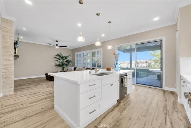 kitchen with pendant lighting, white cabinetry, dishwasher, sink, and a kitchen island with sink