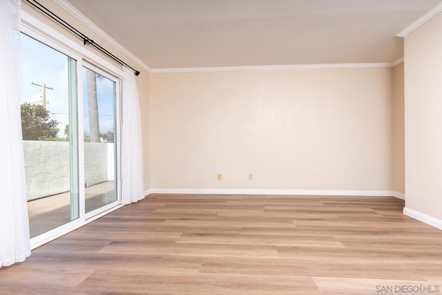 empty room with ornamental molding and light wood-type flooring