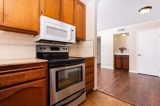 kitchen with tasteful backsplash, light stone counters, stainless steel electric stove, and crown molding