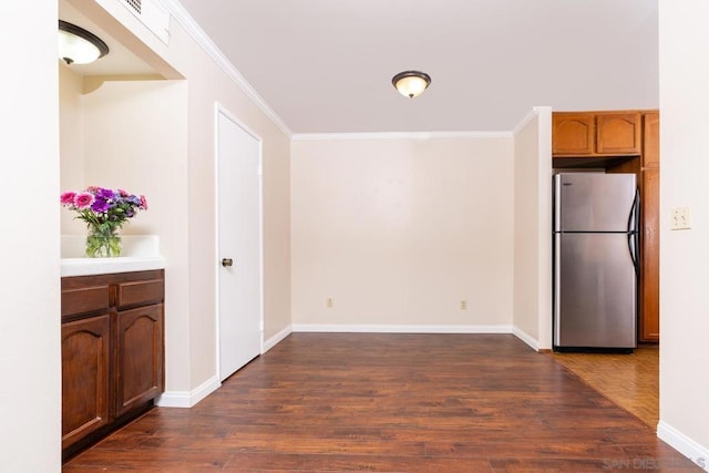 kitchen featuring stainless steel refrigerator, crown molding, and dark hardwood / wood-style flooring